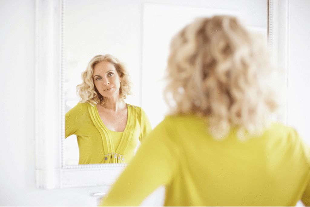 kobieta 40 + przed lustrem, Jak wyglądać szczuplej w ubraniach?